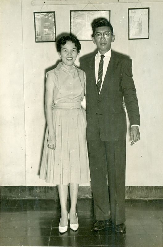 A formally dressed couple standing for a portrait